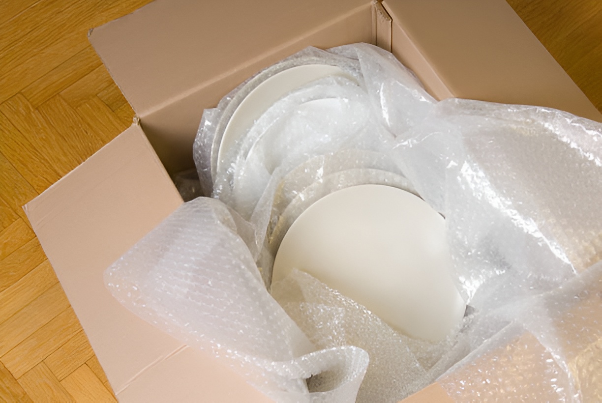 dishes in a moving box, covered in bubble wrap